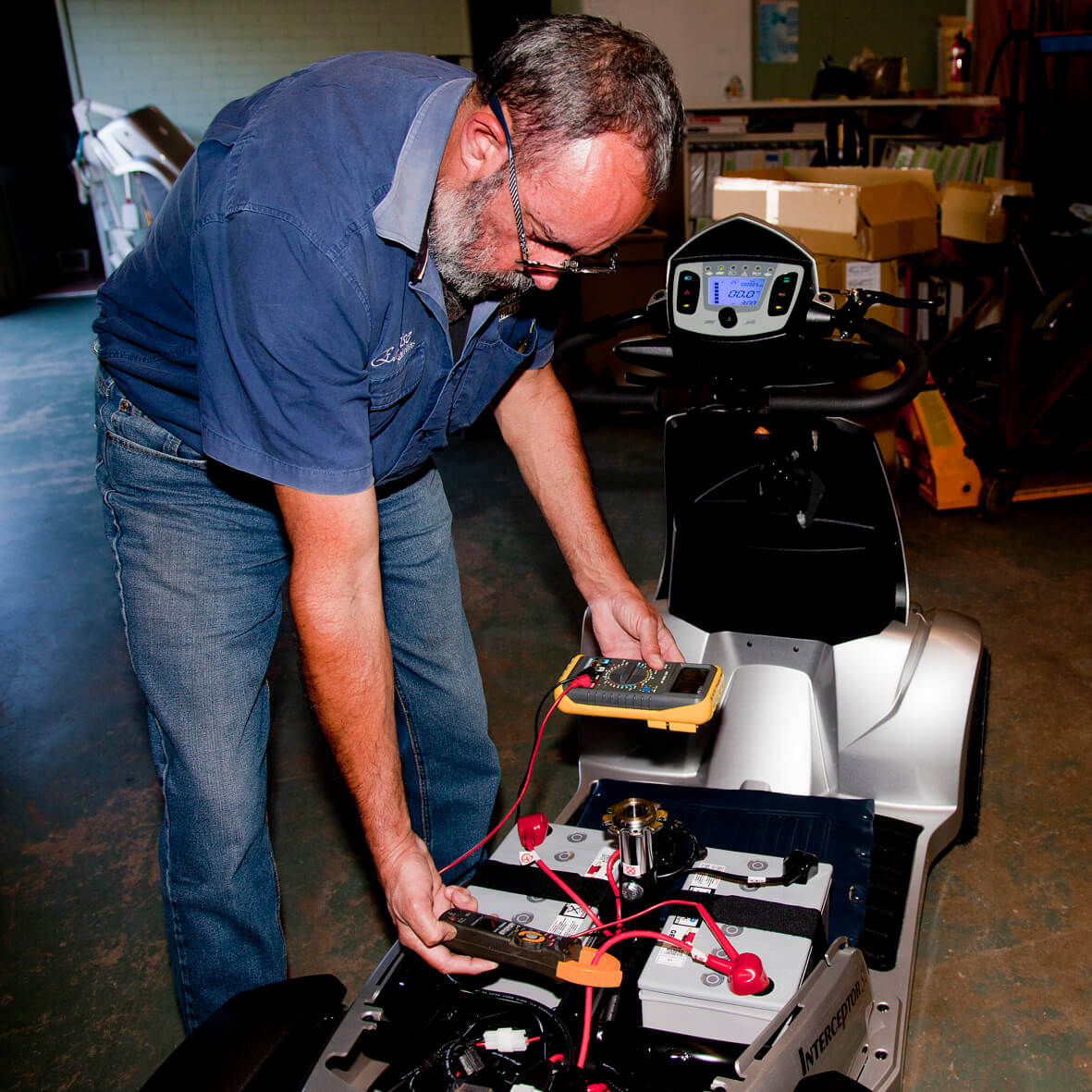 A man inspecting batteries and chargers at Emprise Mobility